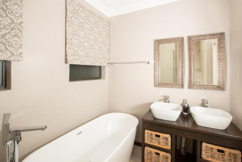 科克斯塔德Guesthouse Fort Knox的带浴缸、水槽和镜子的浴室
