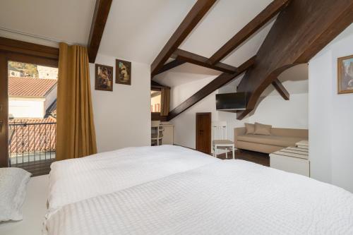 圣洛伦佐因巴纳莱Hotel Opinione Dimora Storica的卧室配有白色的床和沙发