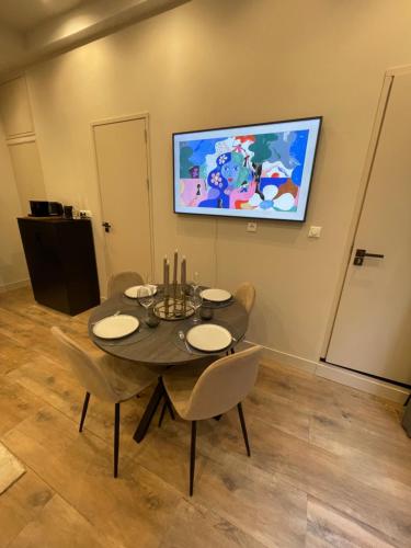 阿姆斯特丹Amsterdam Grachtenappartement的一间设有桌子和墙上电视的用餐室