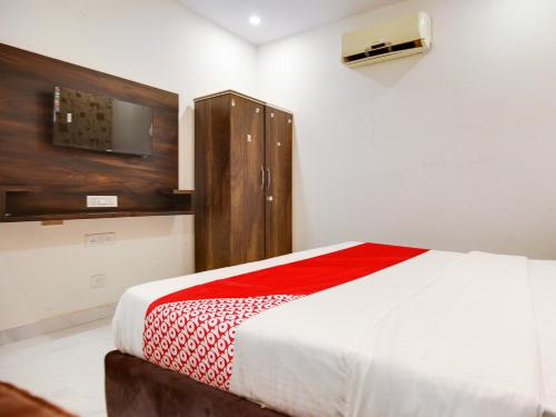 卢迪亚纳OYO Flagship Golden A的卧室配有一张床,墙上配有电视。