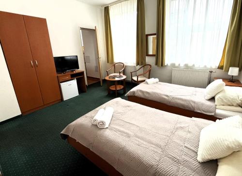 布达佩斯Broadway City Guesthouse的酒店客房设有两张床和电视。