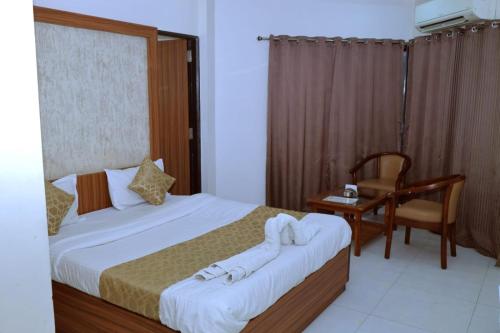 锡尔瓦萨Kings Resort的一间卧室配有两张床、一张桌子和一把椅子