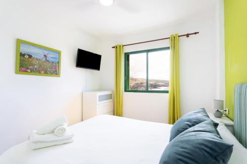 圣胡安海滩Nice 2 bd apartment by the sea in Playa San Juan的一间卧室设有一张床和一个窗口