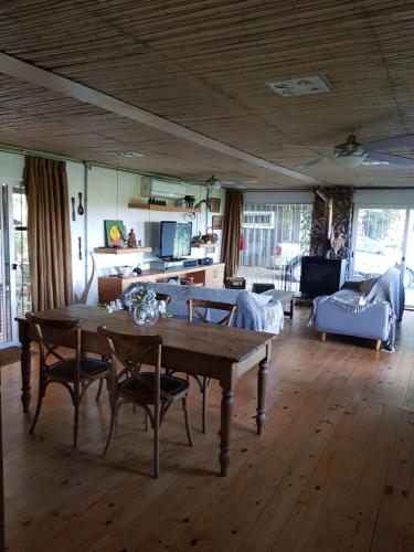 米纳斯Piedra De Agua Chacra, casa, piscina, bosque, río.的客厅配有木桌和椅子