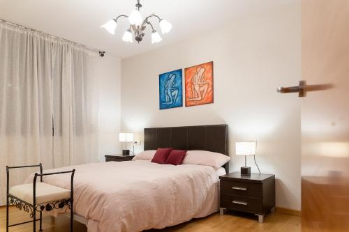 奥尔迪诺AndBnB I 3 Habitaciones con Terraza y Parking的一间卧室配有床和两张桌子及椅子