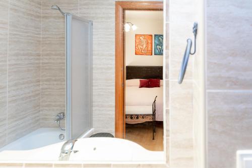 奥尔迪诺AndBnB I 3 Habitaciones con Terraza y Parking的带浴缸、水槽和镜子的浴室