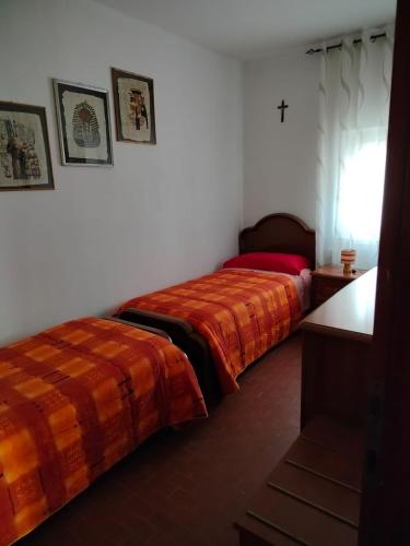 莱维科特尔梅Appartamento al Lago的墙上有十字架的房间,设有两张床