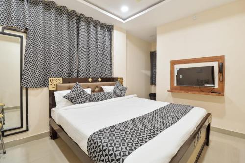 商沙巴HOTEL SANTHOSH DHABA SUITES-NEAR AIRPORT Zone的一间带大床和电视的卧室