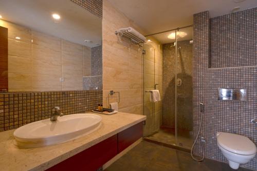 加尔各答切莱斯塔 - 加尔各答酒店的一间带水槽、淋浴和卫生间的浴室