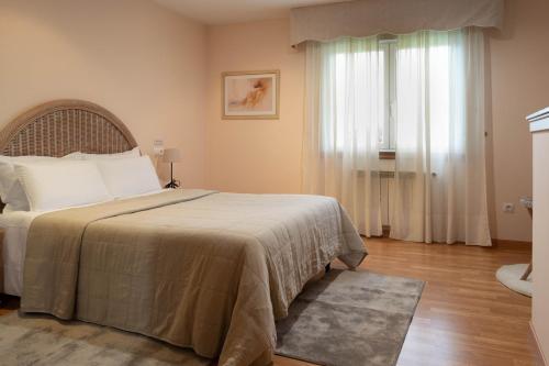 卢戈Motel Bambú的一间卧室设有一张大床和一个窗户。