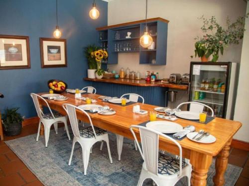 斯特兰德Loddey`s Guest House的一间带木桌和椅子的用餐室