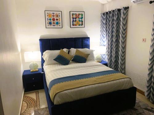 库马西My5 Hotel的一间卧室配有蓝色的床和枕头
