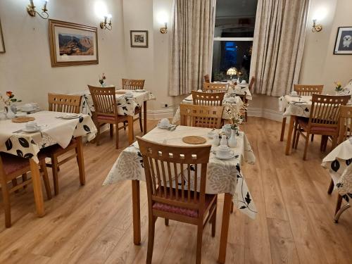 格兰奇奥沃桑茨萨默塞特宫住宿加早餐酒店的用餐室配有桌椅和白色的桌布