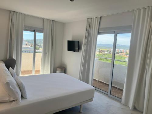 普拉加德阿罗阿罗玛酒店的卧室设有白色的床和大窗户