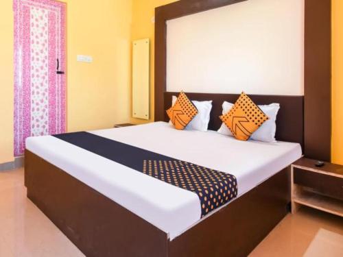 普里HOTEL K.K PALACE的一间卧室配有一张带橙色和蓝色枕头的大床
