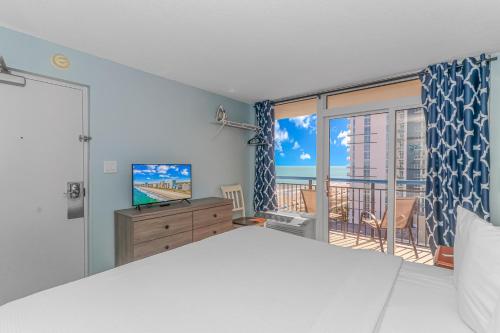 默特尔比奇Newly Renovated King Suite-Ocean Views! Boardwalk 1140的一间带大床的卧室和一个阳台