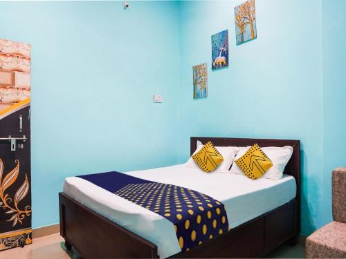 比拉斯布尔OYO Hotel Hanu Inn的一间卧室配有一张蓝色墙壁的床