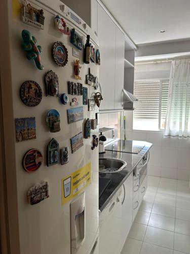 马德里Cómoda Habitación Individual的厨房配有带磁铁和水槽的冰箱