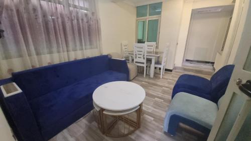 亚的斯亚贝巴Getu furnished apartments at CMC的客厅配有蓝色的沙发、桌子和椅子
