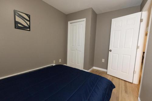 泽西市2-Bed Stylish Space mins to NYC的一间卧室设有蓝色的床和白色的门
