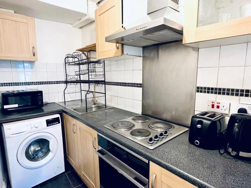 伦敦Hoxton Studios by DC London Rooms的厨房配有炉灶和洗衣机。