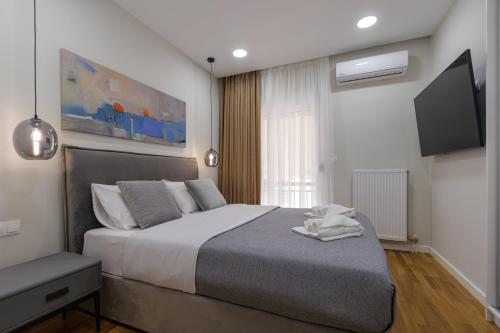 雅典Magnificent Riviera Residence的一间卧室配有一张大床和一台平面电视