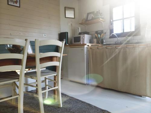 Mons-BoubertLa petite forêt的厨房配有桌子、两把椅子和台面