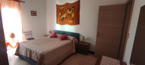 因佩里亚Casa Giusy的一间卧室配有一张带红色枕头的床
