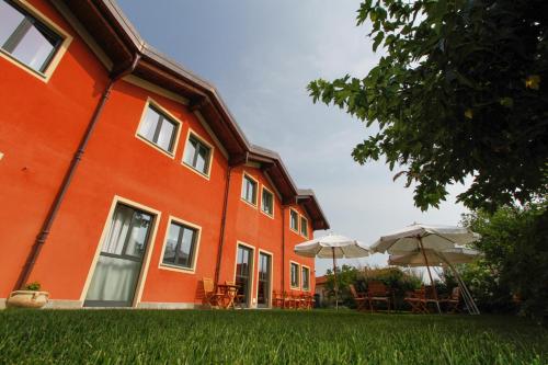 维拉诺瓦蒙多维阿尔伯格黛尔拉陶瓷酒店的一座橙色的建筑,在院子里设有桌子和遮阳伞