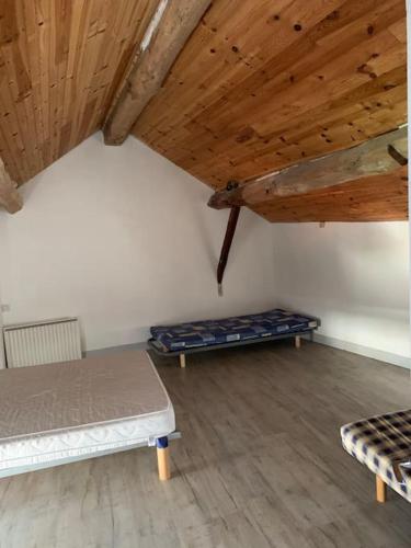 阿斯顿Maison de montagne 8 couchages的客房设有两张床和木制天花板。