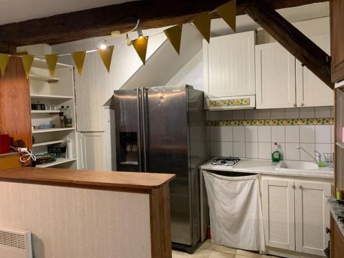 阿斯顿Maison de montagne 8 couchages的厨房配有不锈钢冰箱和白色橱柜