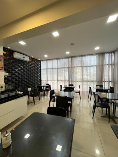 马塞约Mcz Hotel的用餐室设有桌椅和窗户。