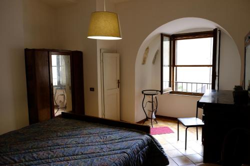 圣杰米尼La casa di una volta的一间卧室设有一张床和一个大窗户