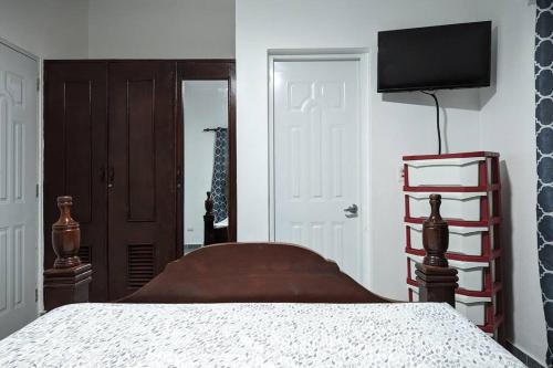 圣斐利-银港Habitación a 5 min de la playa的一间卧室配有一张床和一台平面电视