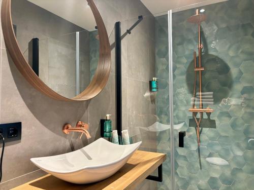 奈梅亨Hotel La Boutique的浴室配有盥洗盆和带镜子的淋浴