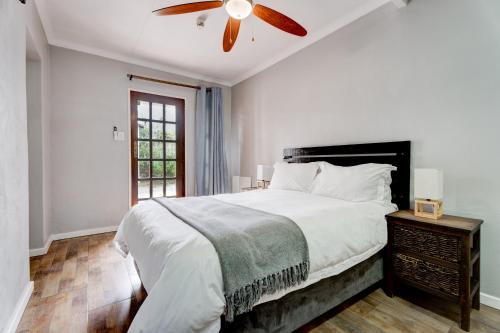比勒陀利亚The Bosau Guest House的一间卧室配有一张床和吊扇