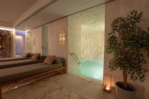 里斯本里斯本佩索阿酒店的一间带沙发和植物浴缸的浴室