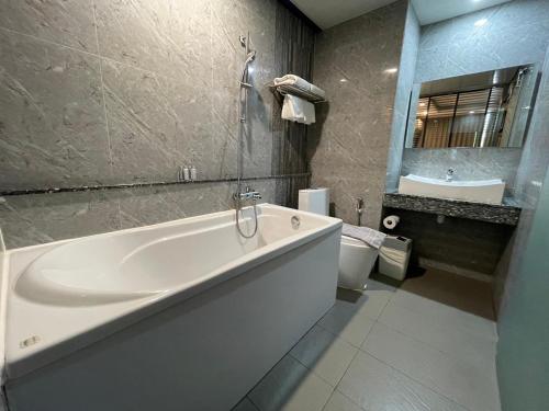 曼谷Bangkok City Link Hotel的浴室配有大型白色浴缸和水槽