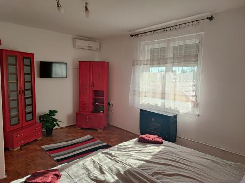 豪伊杜索博斯洛Szaffi apartman的一间卧室配有一张床和一个红色橱柜