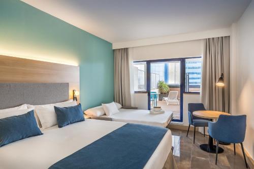 穆尔西亚Occidental Murcia Agalia的配有一张床和一张书桌的酒店客房