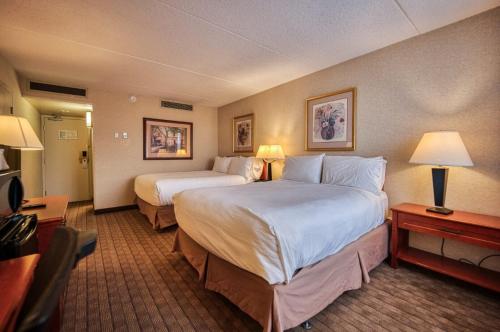 卡尔加里Amenida Residences, Calgary的酒店客房设有两张床和电视。