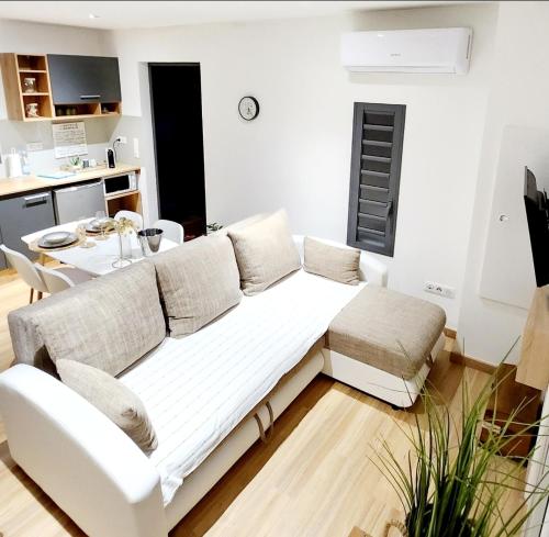 Le LambertAu Doux Refuge的客厅配有白色的沙发和桌子