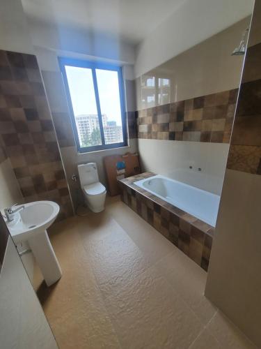 亚的斯亚贝巴LEYO FURNISHED APARTMENTS的带浴缸、卫生间和盥洗盆的浴室
