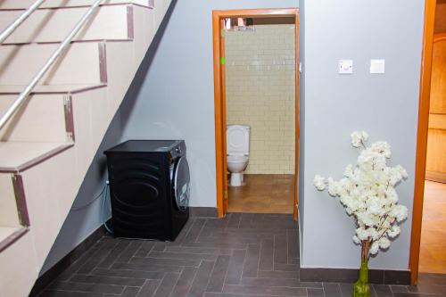 TokuseAccra cosy homes - Krokobite Beach的走廊上设有带卫生间的浴室和电视。