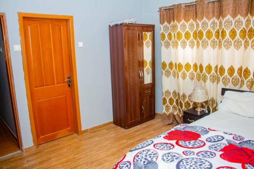 TokuseAccra cosy homes - Krokobite Beach的一间卧室配有一张床和一扇木门