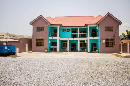 TokuseAccra cosy homes - Krokobite Beach的蓝色和粉红色的大房子