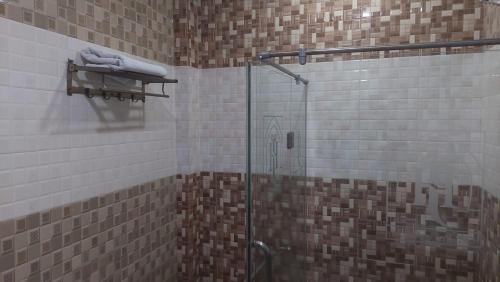 锡亚尔科特Javson Airport Hotel的带淋浴的浴室和玻璃门