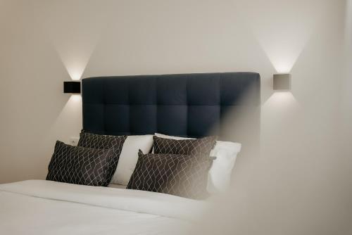 布拉加A 0.4 - Alexa Smart House的一张带蓝色床头板和枕头的床