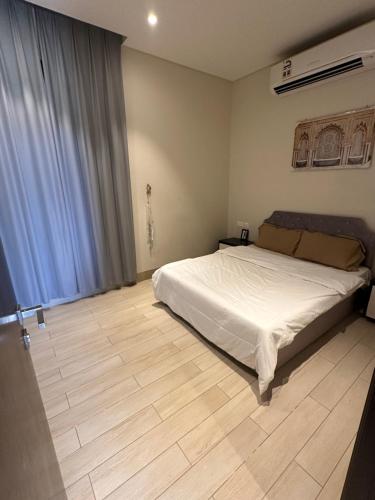 塞拉莱Abu sjood的一间卧室配有一张床,铺有木地板