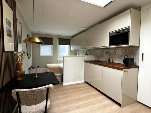 霍勒姆43号一室公寓的厨房配有白色橱柜和桌椅